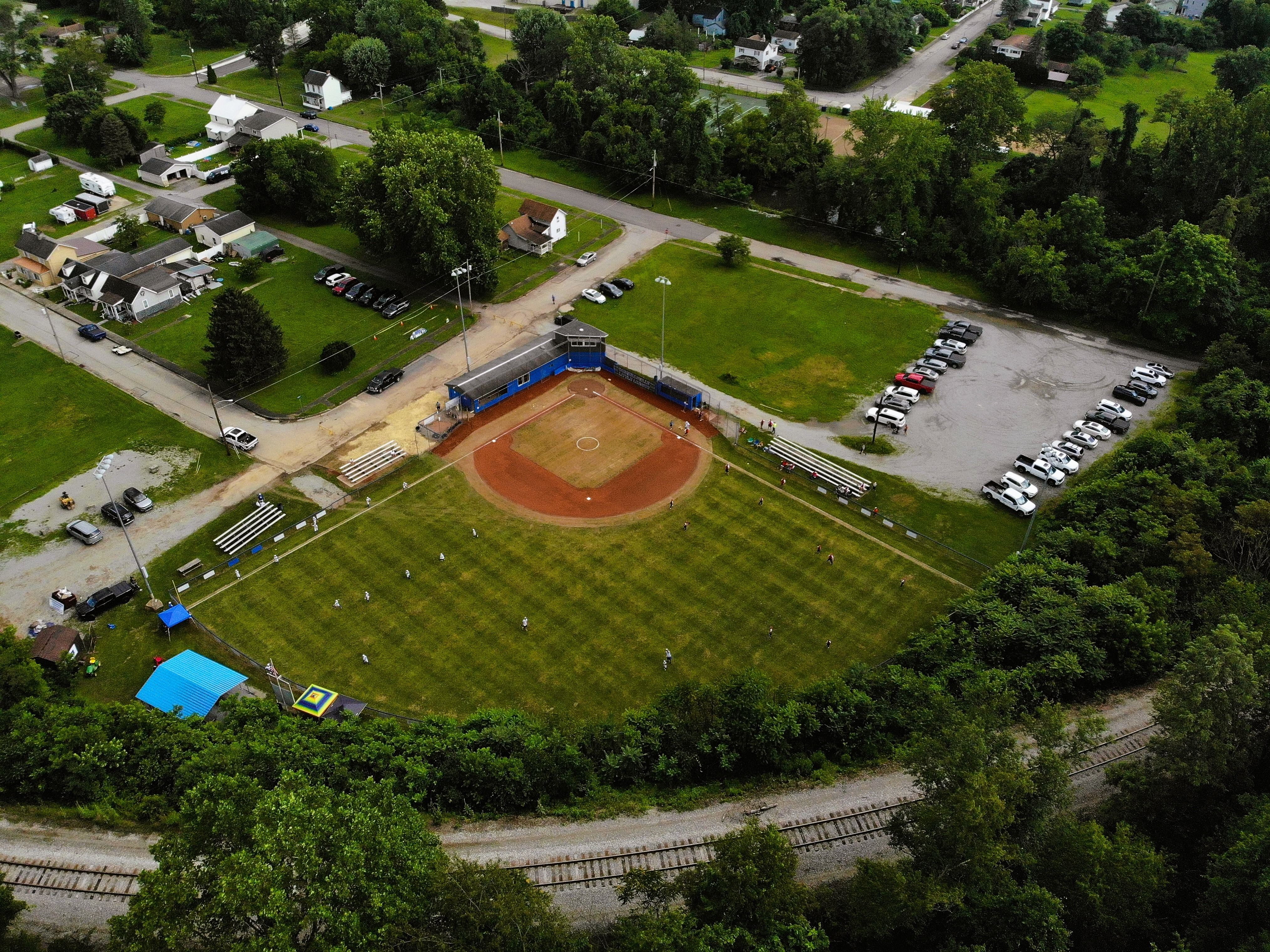 Aerial overview of a community ballpark with bleachers and parking
