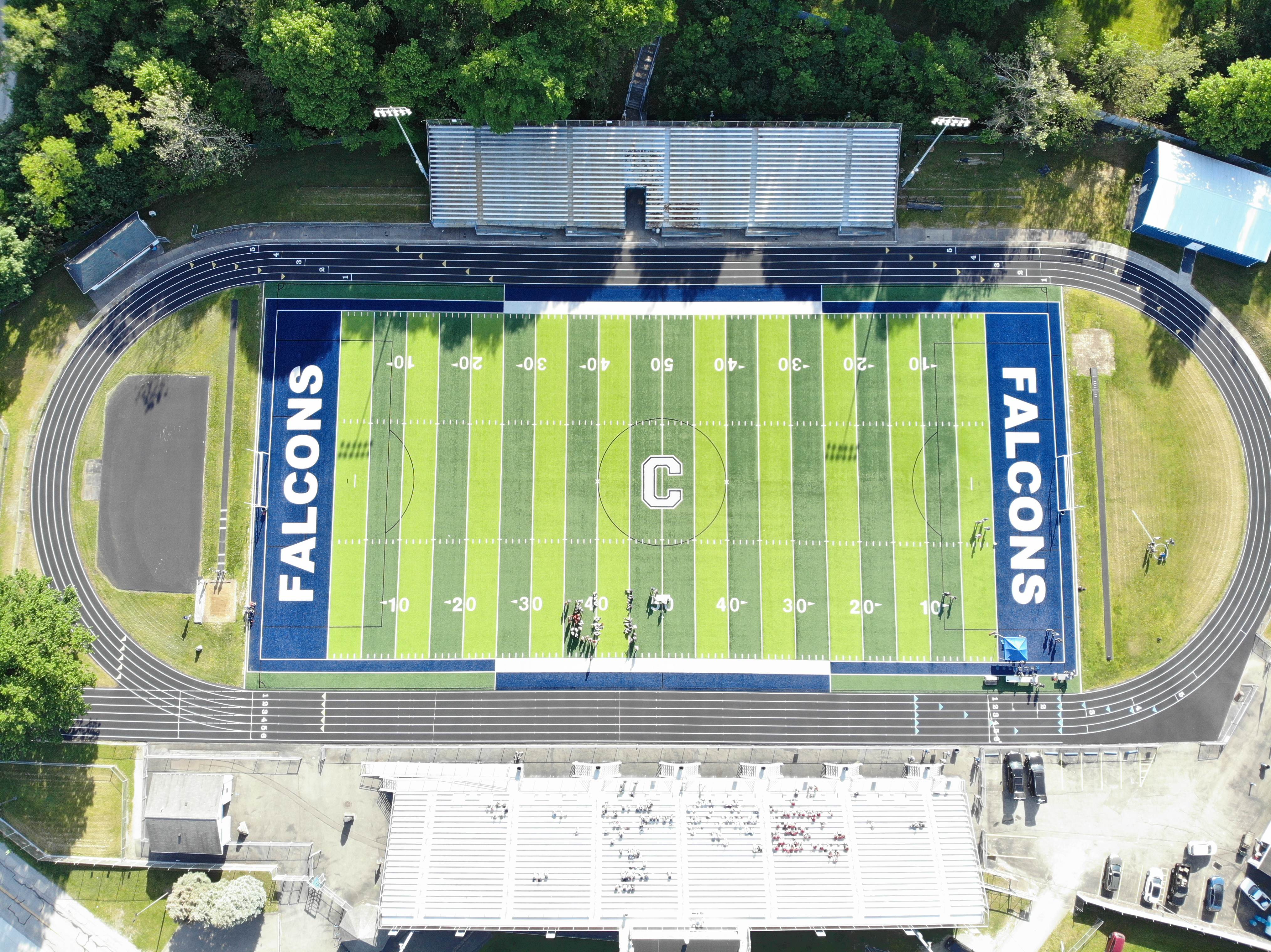 Top-down aerial of a football stadium with track and end zone branding